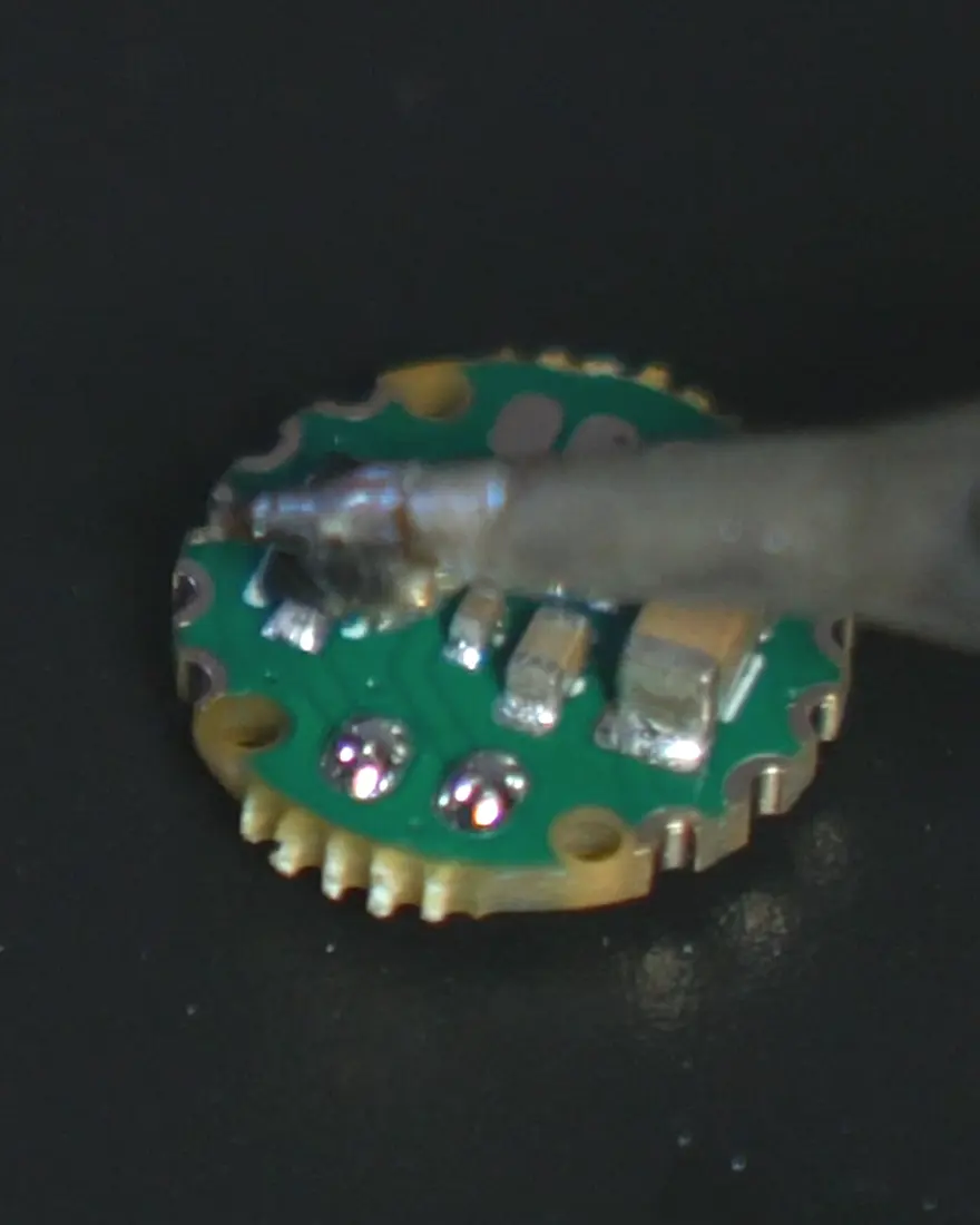 A soldering iron on a M'AKOMA bead circuit, smaller than a fingertip
